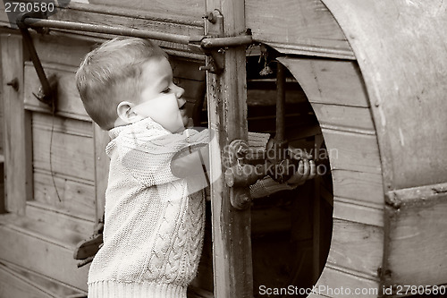 Image of 2 years old curious Baby boy managing with old agricultural Mach