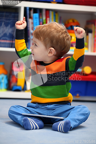 Image of Successful 2 years old boy winning using a digital tablet comput