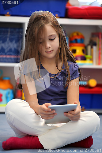 Image of Happy pre-teen girl using a digital tablet computer
