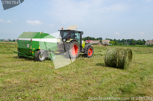 Image of tractor bailer collect hay in agriculture field 