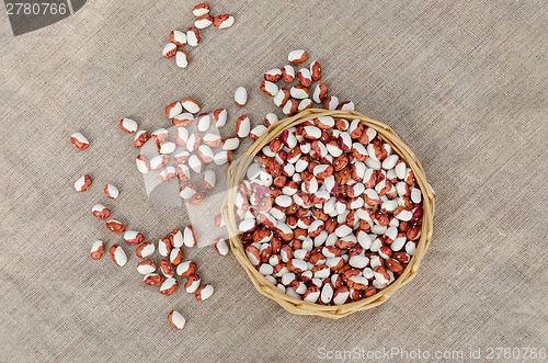 Image of organic beans in wicker basket on linen texture  