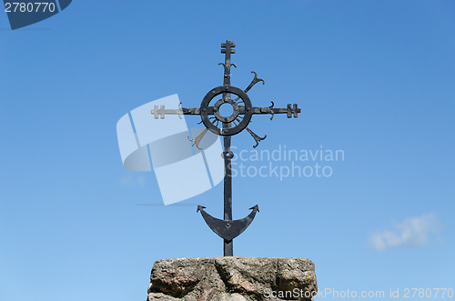 Image of metal ornamented cross on blue sky background 