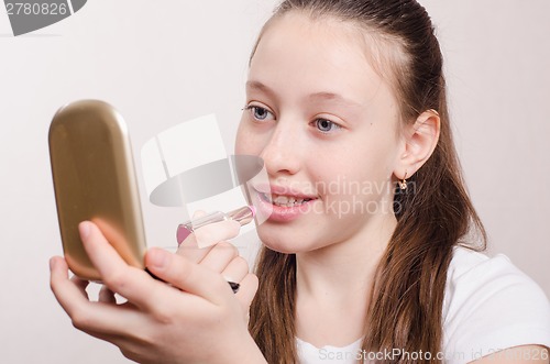 Image of Girl paints lips with lipstick