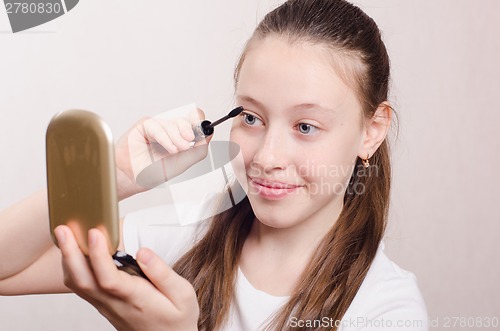 Image of Teen girl paints eyelashes