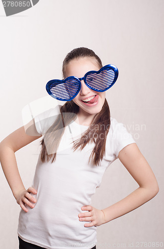 Image of Funny little girl in big glasses showing tongue