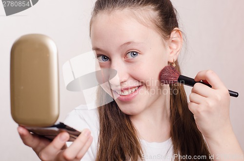 Image of Twelve year old girl gets brush powder on cheek