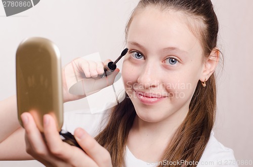 Image of Happy teen girl paints eyelashes