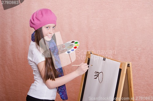 Image of The girl begins to draw picture on the easel