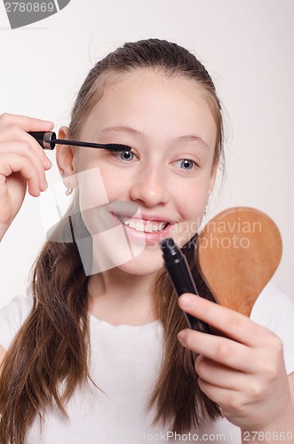 Image of Teenager paints eyelashes mascara