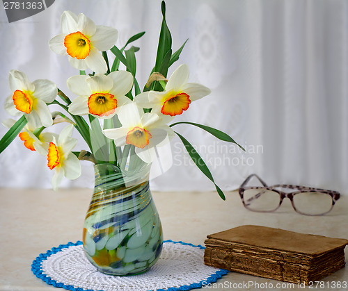 Image of Blossoming narcissuses in a vase on a table.