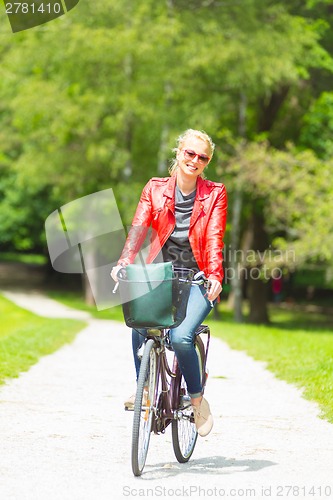 Image of Young woman riding a bicycle.