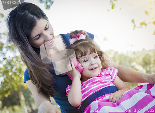 Image of Mother and Cute Baby Daughter Playing with Cell Phone