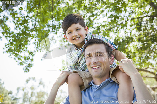 Image of Father and Son Playing Piggyback in the Park