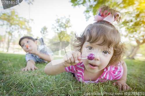 Image of Cute Baby Girl and Brother with Lollipops in Park