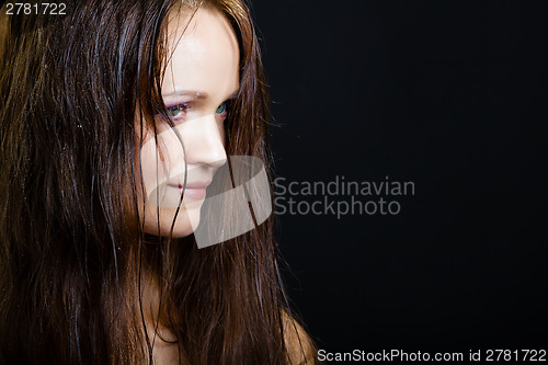 Image of portrait of a young girl with long wet hair on a black