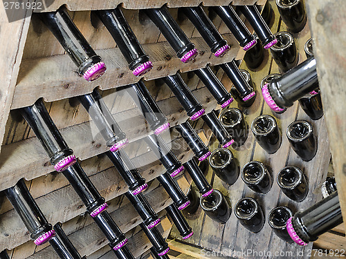 Image of Wood rack stand with bottles of white dry sparkling wine