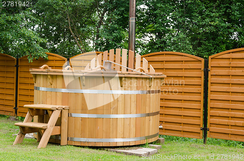 Image of modern wooden water hot tub with stairs outdoor 