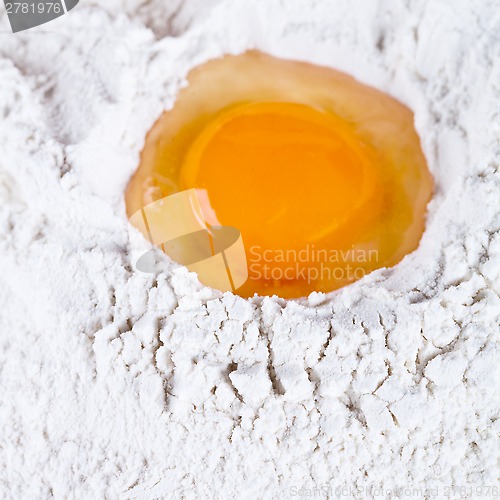 Image of broken egg on flour