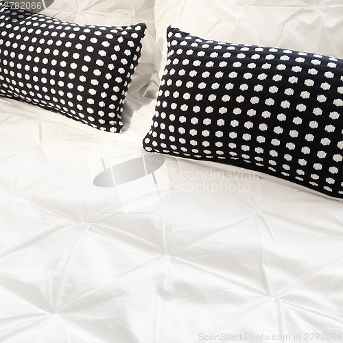 Image of White bed linen with black cushions