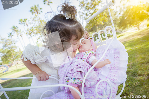 Image of Adorable Young Baby Girl Playing with Baby Doll and Carriage