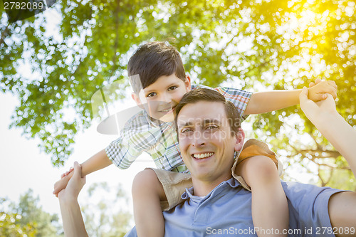 Image of Father and Son Playing Piggyback in the Park