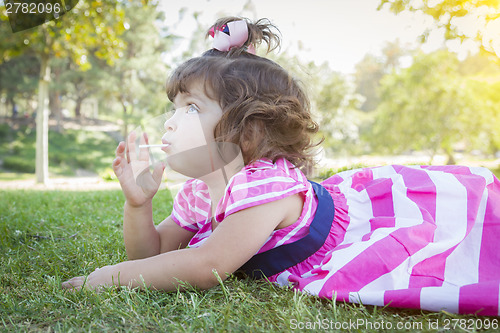 Image of Cute Baby Girl Enjoying Lollipop Outdoors