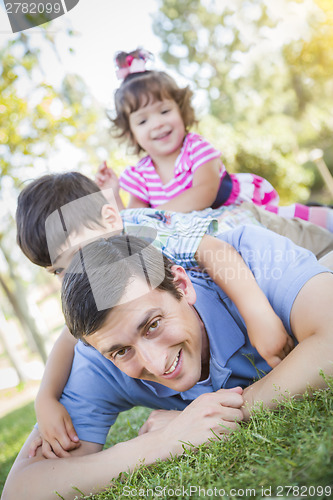 Image of Young Son and Daughter Having Fun With Their Dad Outdoors