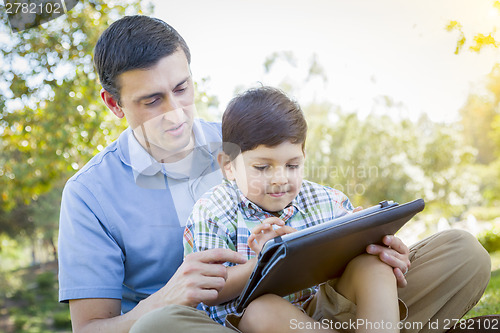 Image of Handsome Mixed Race Father and Son Playing on Computer Tablet