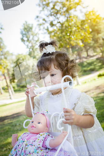 Image of Adorable Young Baby Girl Playing with Baby Doll and Carriage