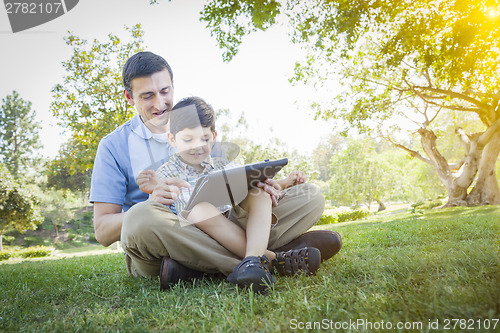 Image of Handsome Mixed Race Father and Son Playing on Computer Tablet