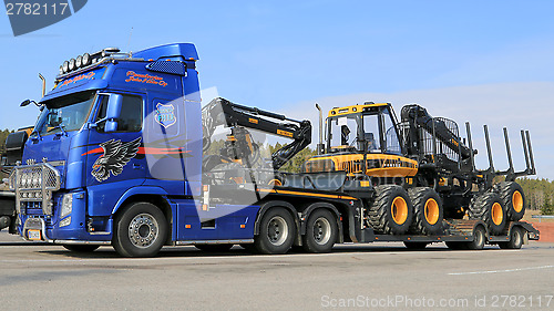 Image of Blue Volvo FH13 Truck Hauling Ponsse Forestry Machinery
