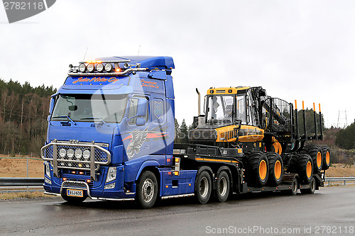 Image of Blue Volvo FH13 Truck Hauls Ponsse Forwarder