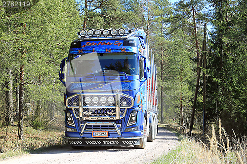 Image of Blue Volvo FH16 750 Timber Truck on Forest Road