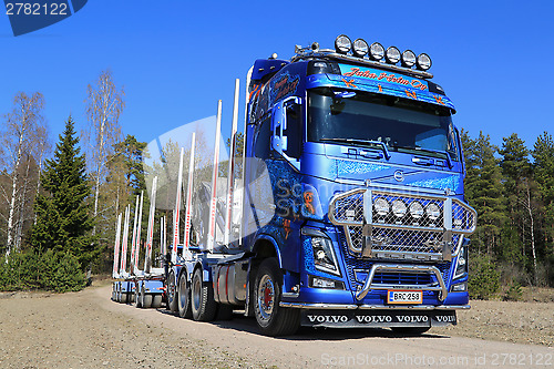 Image of Blue Volvo FH16 750 Timber Truck on Rural Road