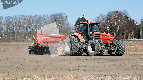 Image of Same Agricultural Tractor and Seeder on Field at Spring