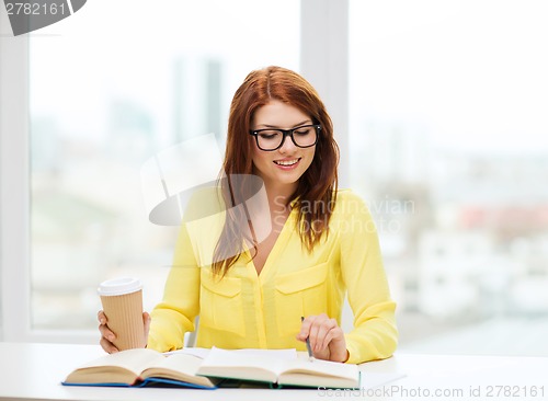 Image of smiling student girl reading books in library