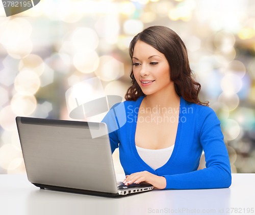 Image of smiling woman in blue clothes with laptop computer