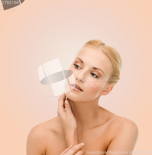 Image of beautiful woman touching her face skin