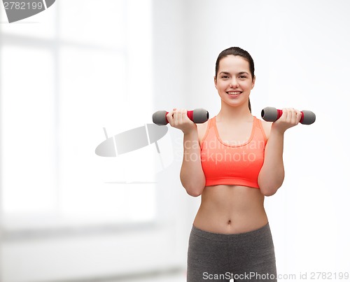 Image of young sporty woman with light dumbbells