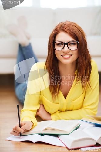 Image of smiling student girl reading books at home