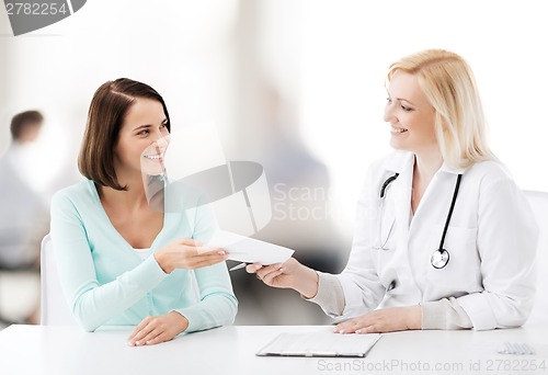 Image of doctor giving prescription to patient in hospital