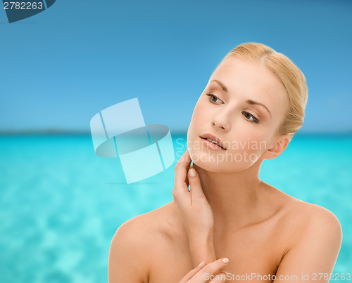 Image of beautiful woman touching her face skin