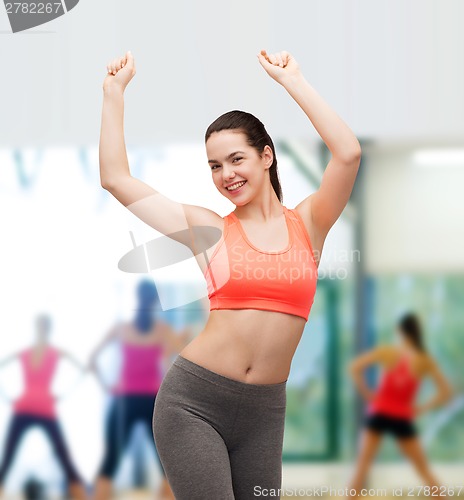 Image of smiling teenage girl in sportswear dancing