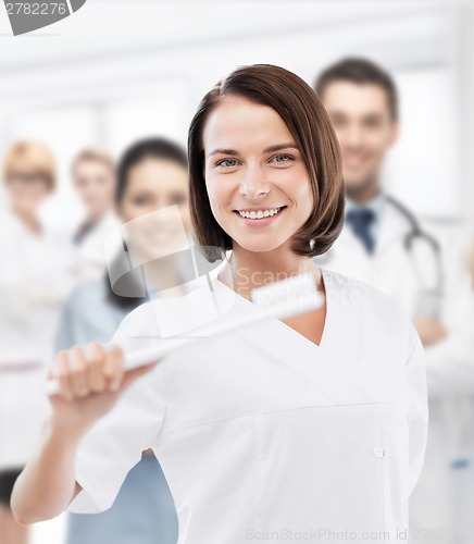 Image of dentist with toothbrush in hospital