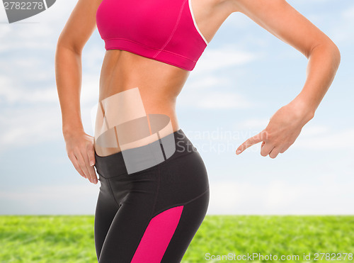 Image of close up of sporty woman pointing at her buttocks