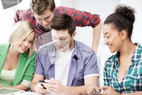Image of students looking at smartphone