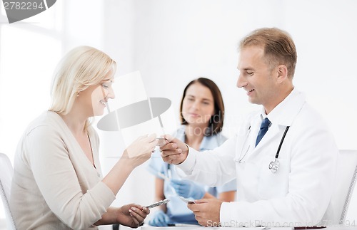 Image of doctor giving tablets to patient in hospital