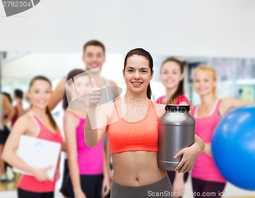 Image of teenage girl with jar of protein showing thumbs up