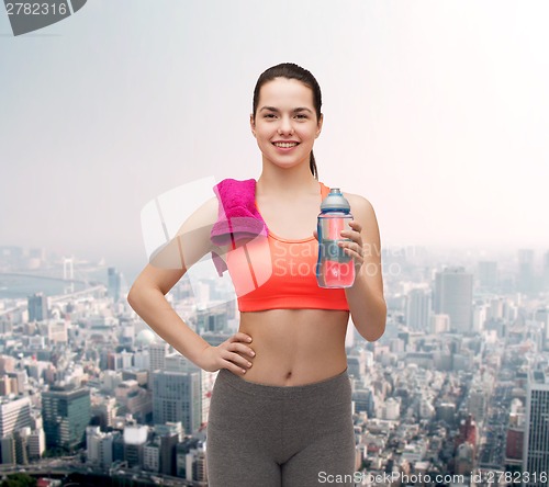 Image of sporty woman with towel and water bottle