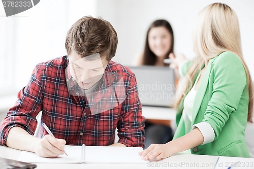 Image of students writing something at school